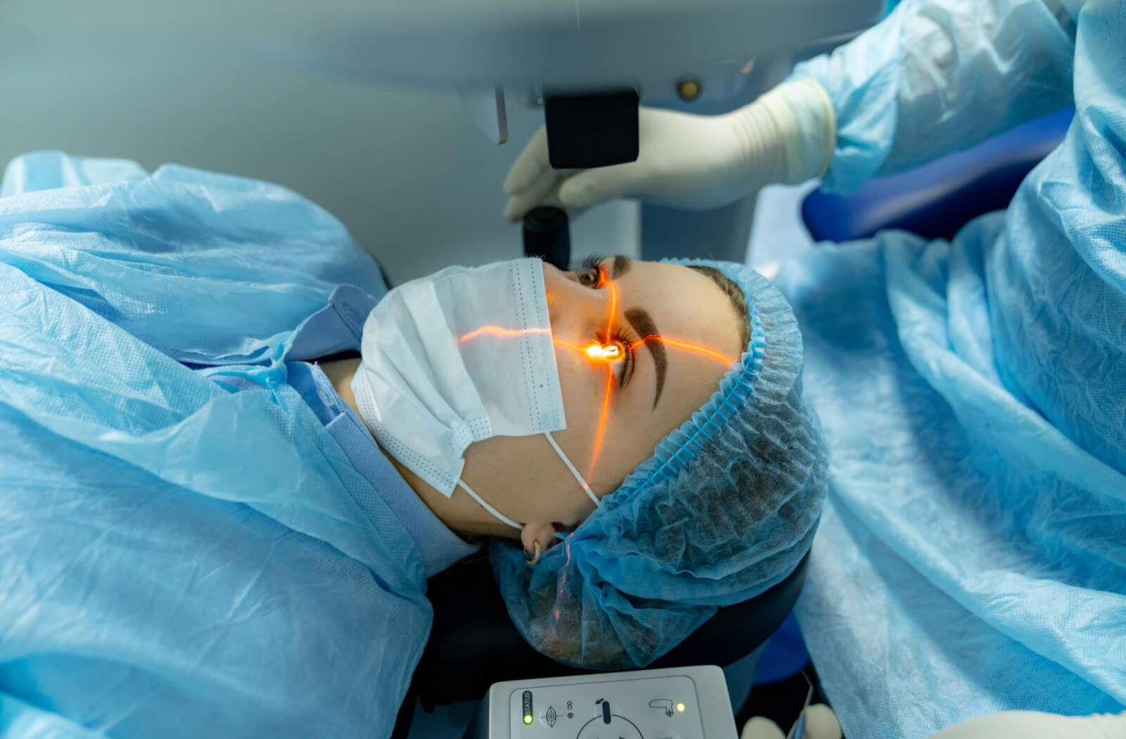 A female patient with cataracts is lying in an operating room. The doctor is using a laser procedure for the surgery.