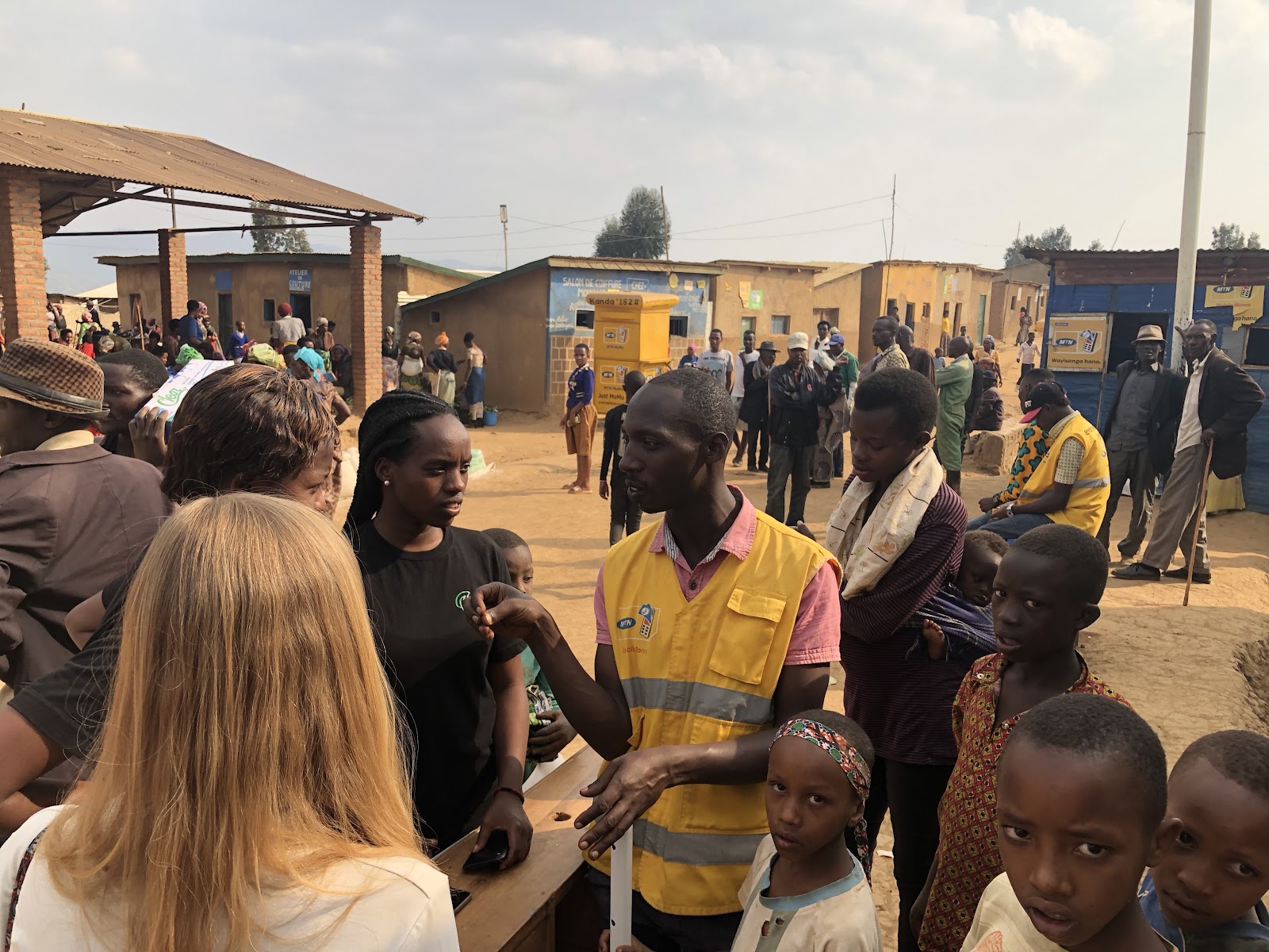 The Leaf team working in a refugee camp with high mobile money penetration. Each yellow sign and person in a yellow vest represents a “cash in” point to the Leaf system through existing telco agents.