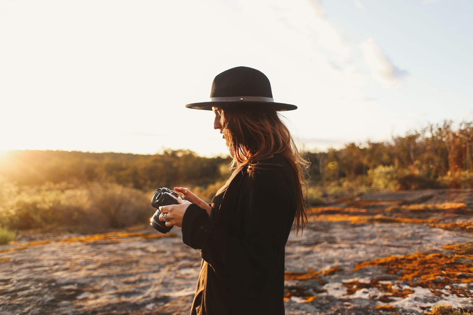 Picture of a lady working with her camera. This is concerning an article on how to insure camera equipment when traveling abroad. 