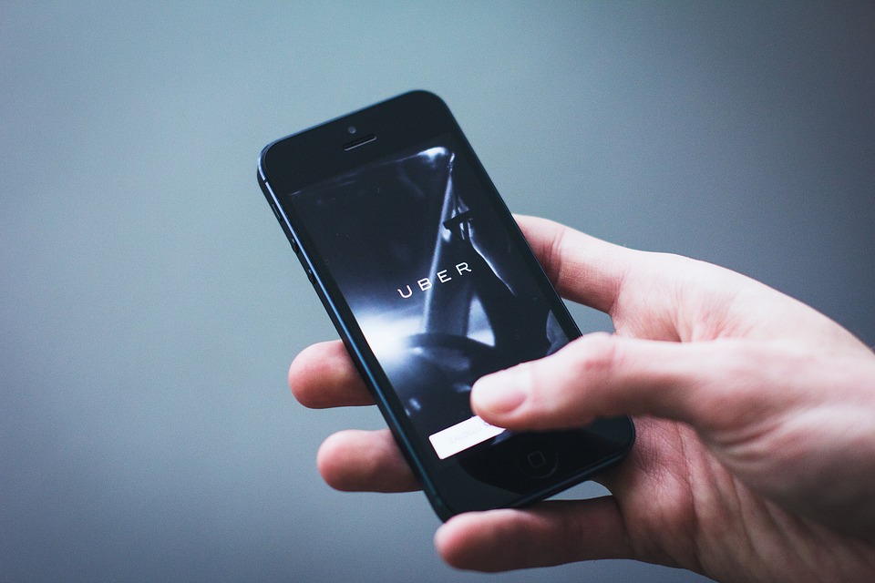 Person holding phone with Uber logo on phone screen