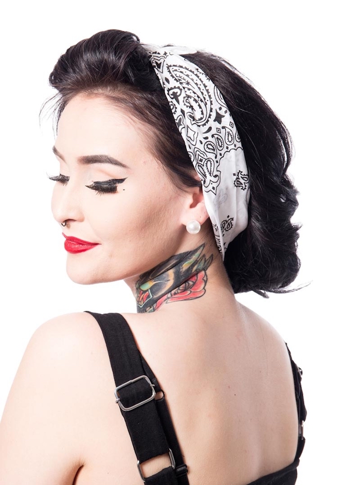 Rockabilly Frisur mit Kopftuch, farbiges Tattoo am Hals, roter Lippenstift und schwarzer Lidstrich 