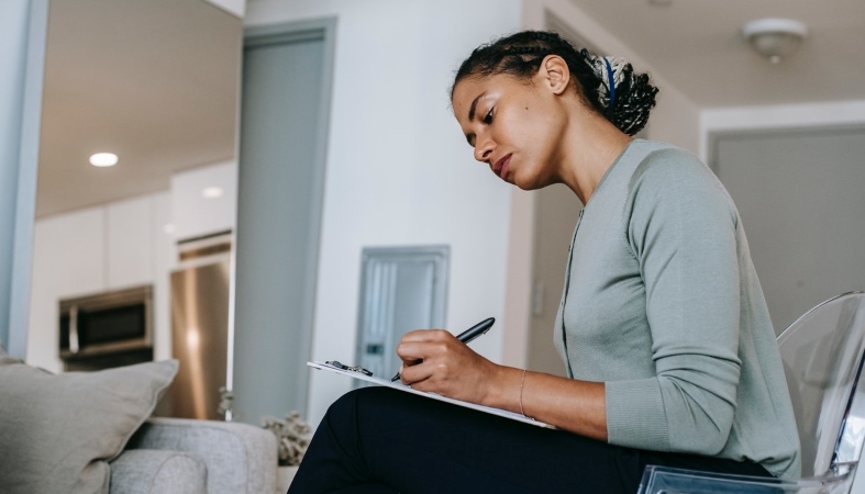 A woman creates a list, building out her home organization system