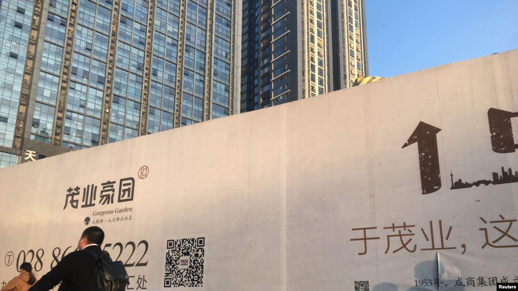 一名男子骑自行车经过四川成都的一处建筑工地 (资料照)