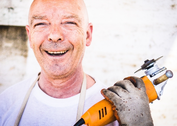 A happy client smiles while holding a grinding tool after getting a great lease at Somerville Auto