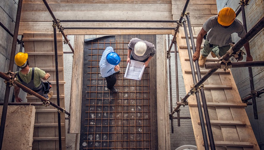 View looking down through scaffolding at construction crew working