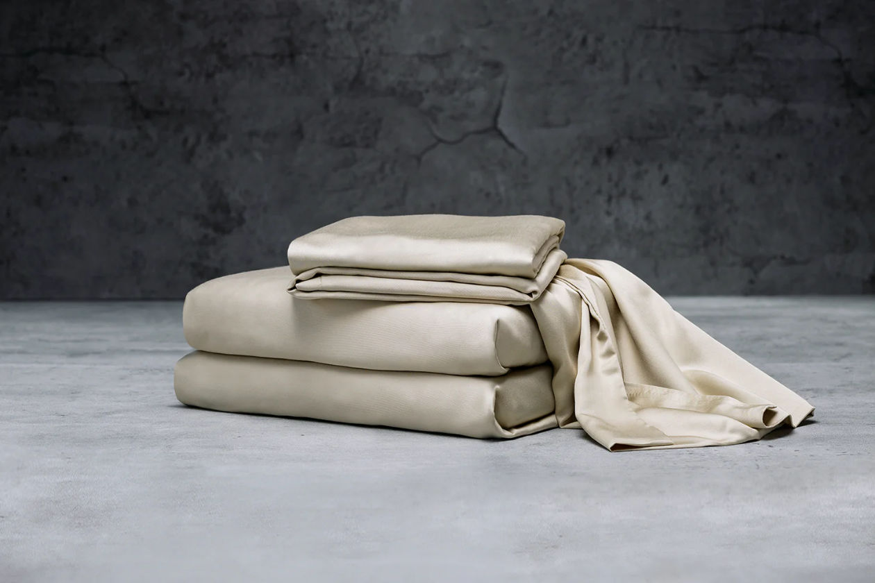 A stack of folded Luxome sheets in beige color.