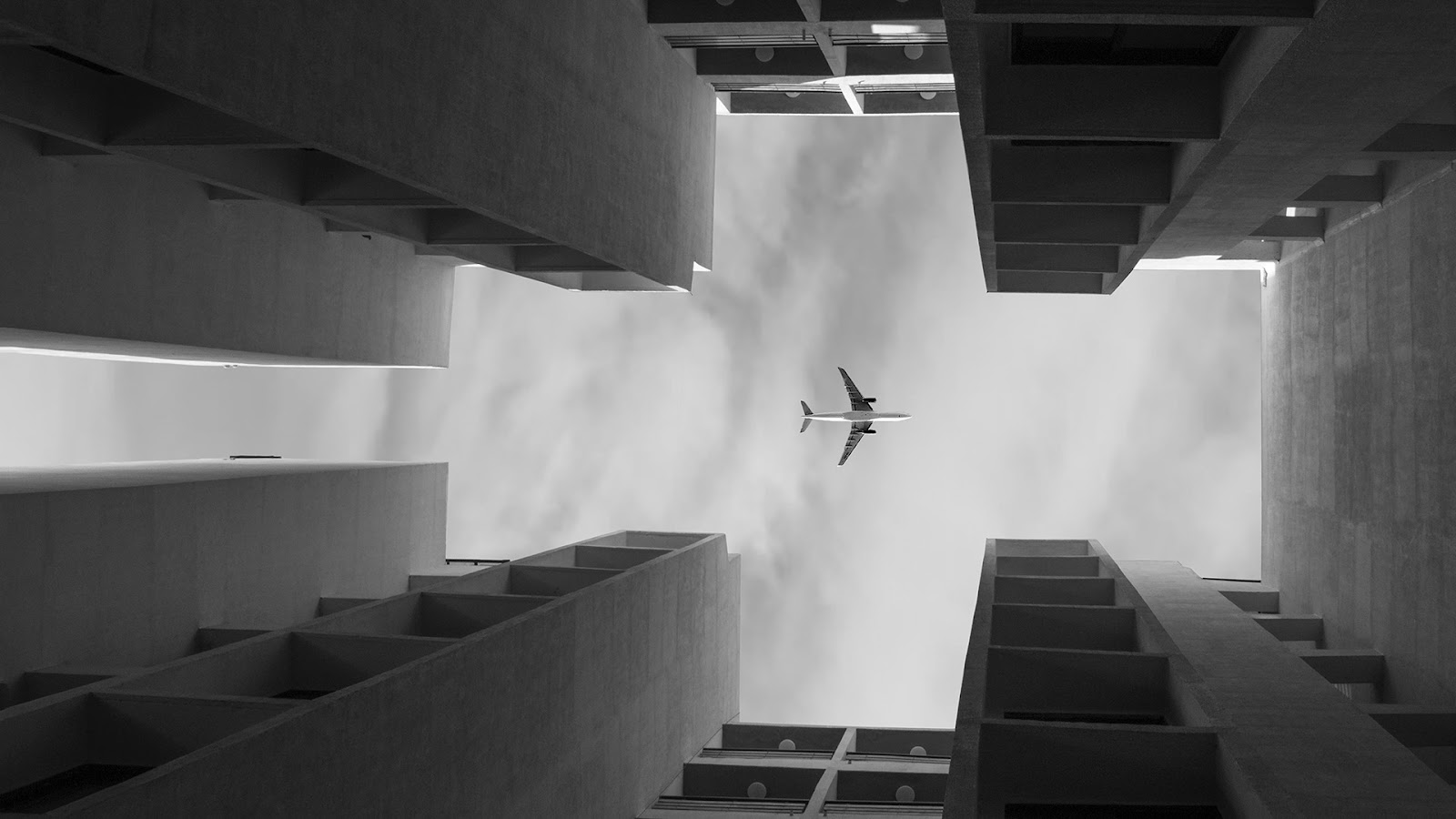 Flygplan inramat av siluetter av byggnader
