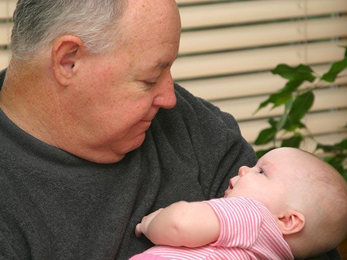 Ein Opa mit seinem Enkel auf dem Arm: Bei Diabetes Typ 2 spielt Vererbung eine größere Rolle als bei Typ 1.
