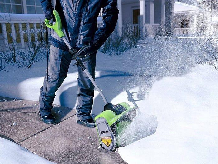image of person pushing the greenworks electric shovel best snow shovels 2021