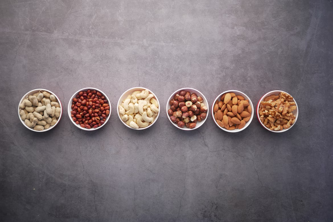 small white dishes with dried beans and nuts on a gray background