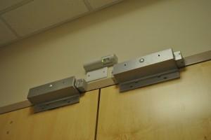 Image from White Oak Security’s blog of a Request to Exit sensor (REX sensor) installed above a door.