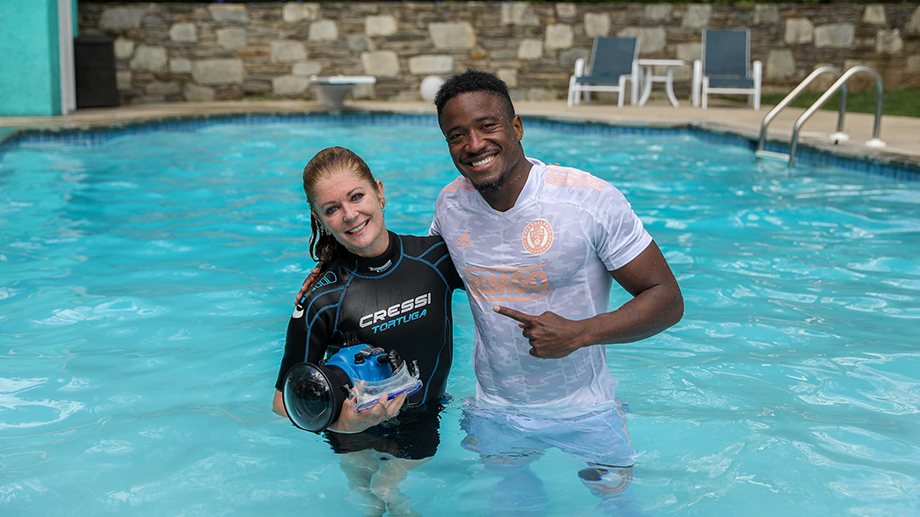 Photographer Julia Lehman and Philadelphia Union soccer player Sergio Santos smile together in the pool for a behind-the-scenes snapshot of the product shoot.