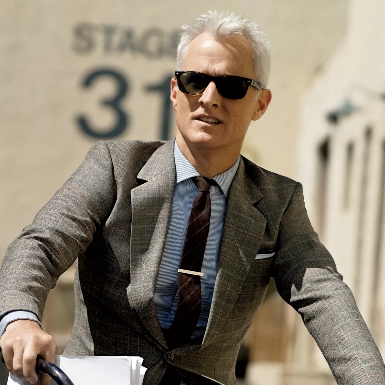 image depicting a man in a suit wearing wayfarer-type, square sunglasses