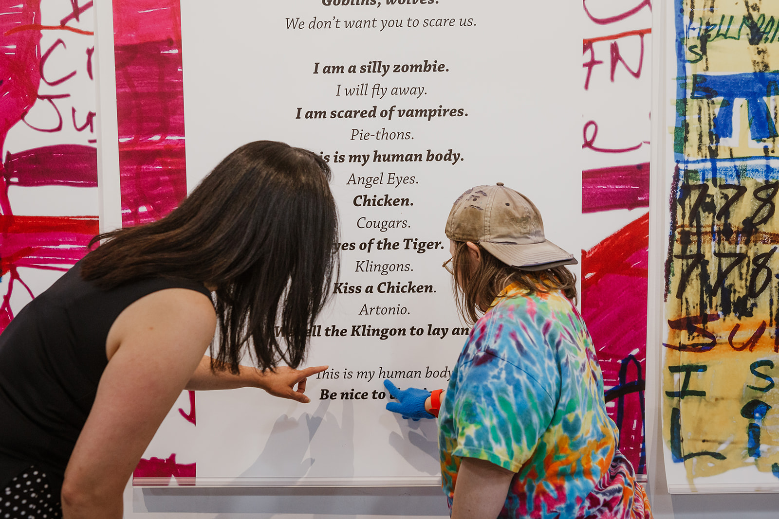 Teresa Pocock shows Jenny Kwan the text 'my human body' in her poem, 'Eyes of the Tiger' on July 22, 2019. Photo: This Is It Studios.