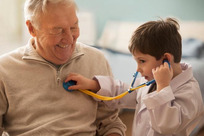 Niño usando un estetoscopio con el abuelo