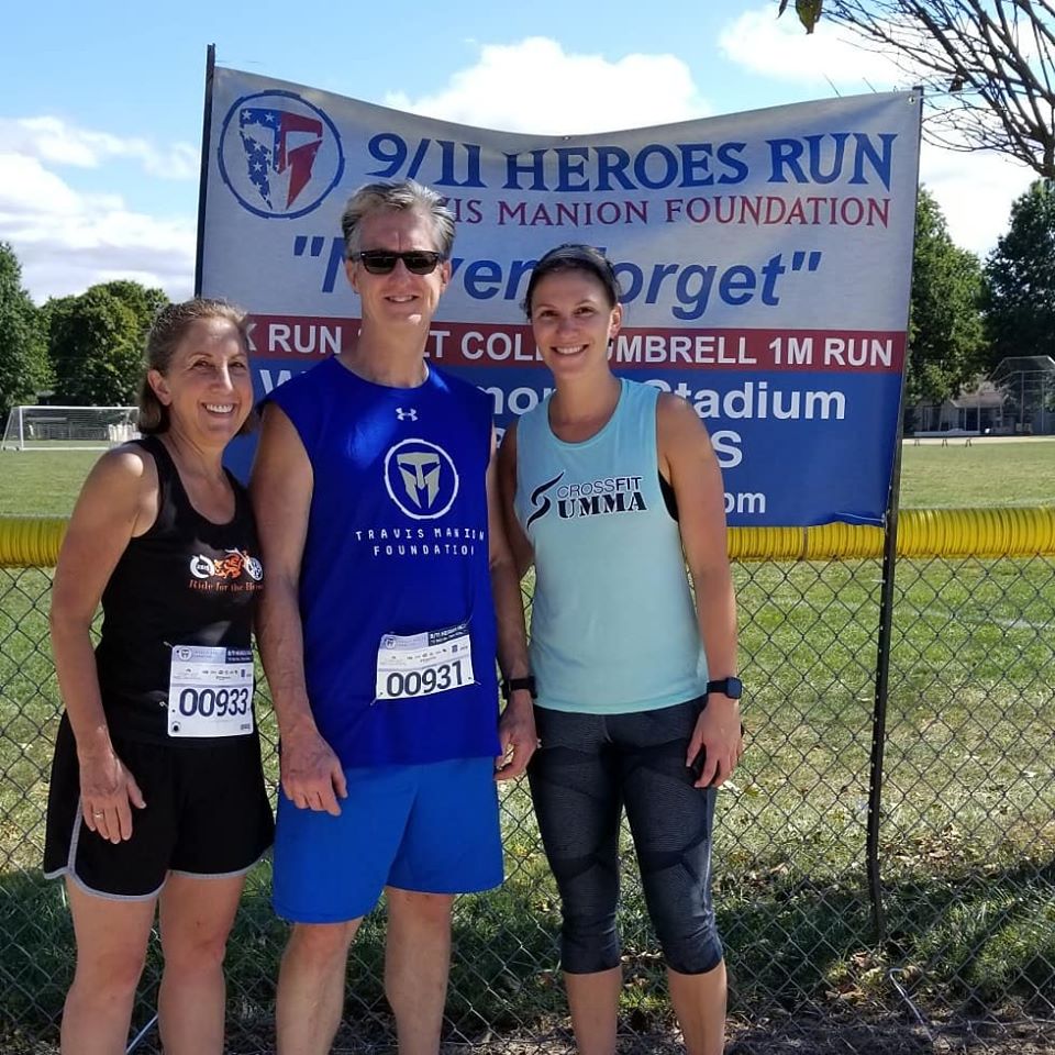 Image may contain: 3 people, people smiling, people standing and outdoor