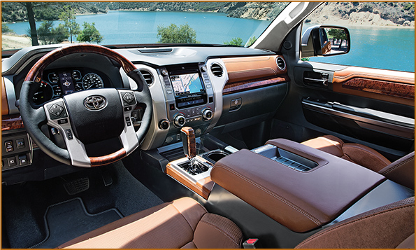 The interior of a 1794 Edition Toyota Tundra with brown leather interior looking out at lake