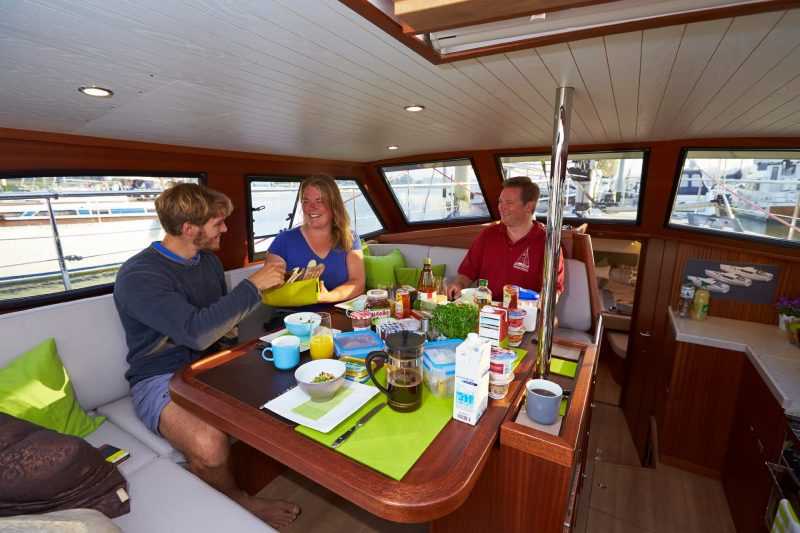 Three person eating on a yacht saloon 