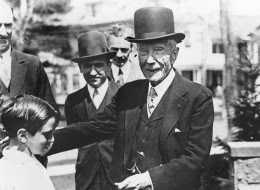 U.S. philantropist and oil magnate John D. Rockefeller gives a dime to a child, in this undated picture. Rockefeller was noted for his habit of giving coins as tips to all and sundry. (AP Photo)