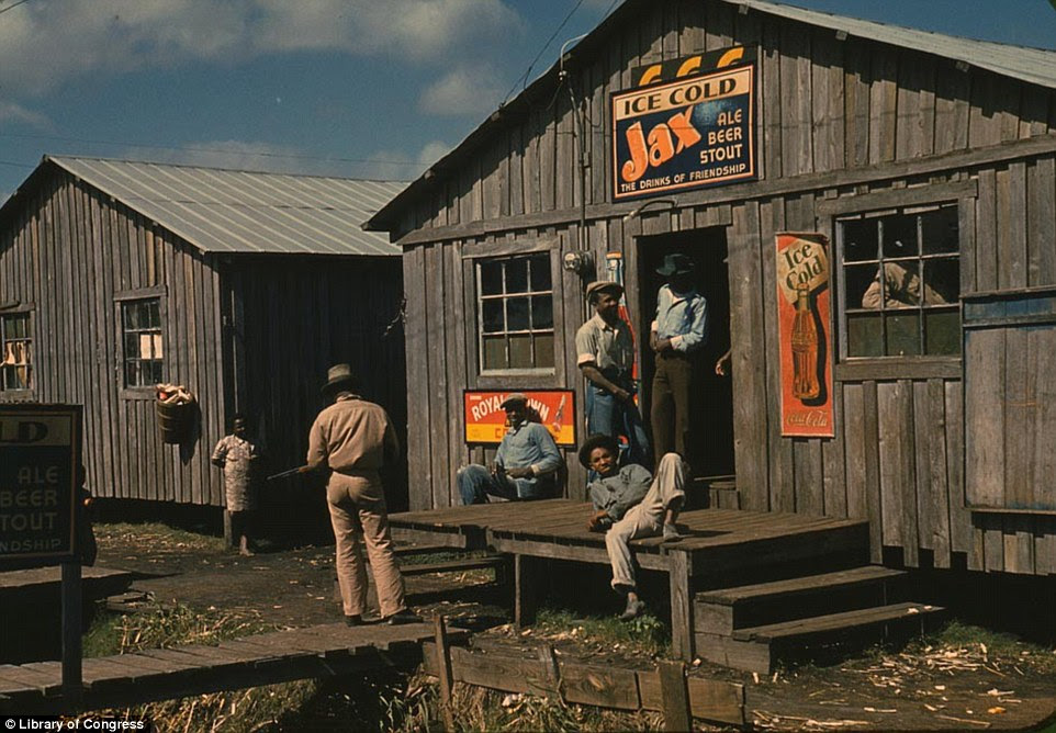 The hard years didn't mean the end of fun. Migrant workers are pictured lounging on the stoop of a living quarter and 'juke joint' in Belle Glade, Florida in early 1941 captured by photographer Marion Post Wolcott