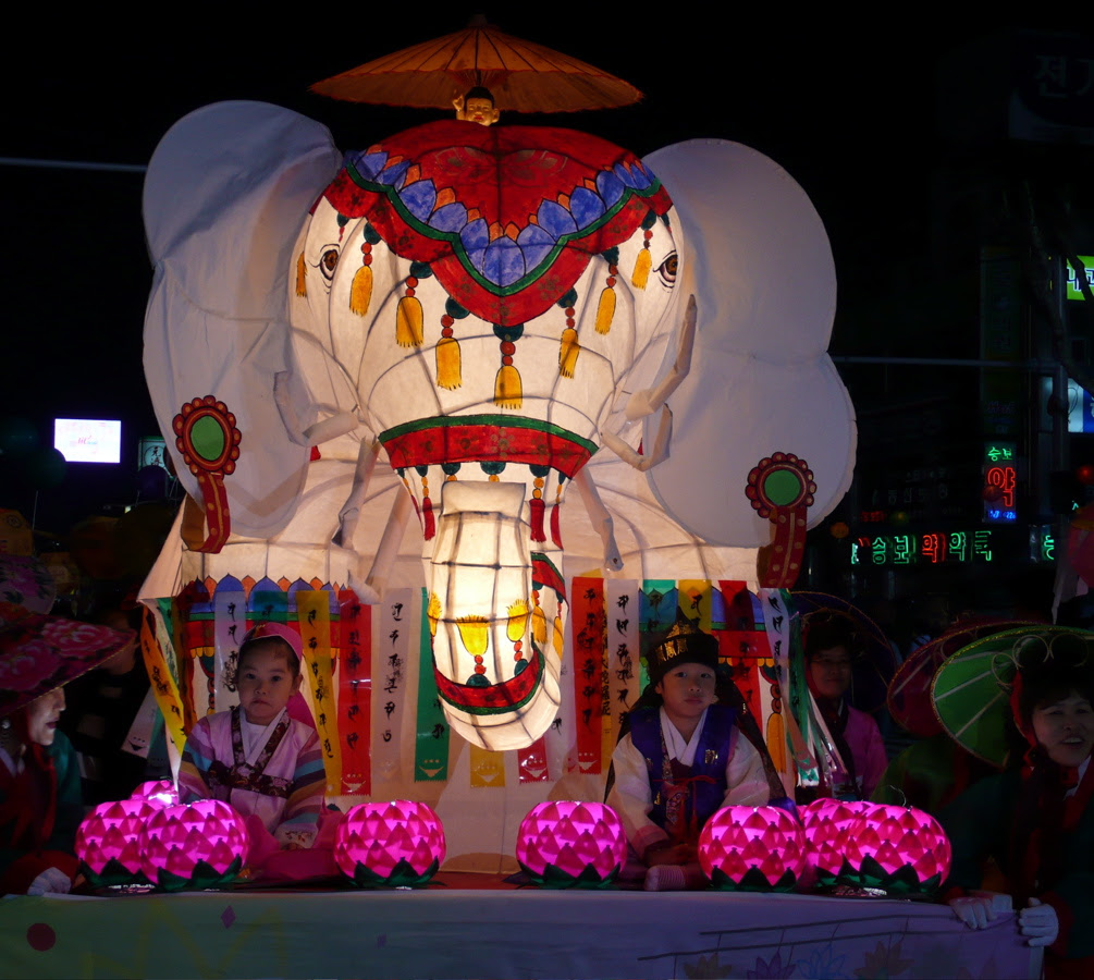 two small children on a float with an elephant on it, in the parade.