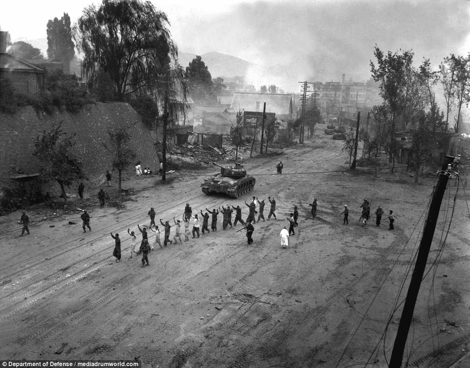 A US Marine tank follows a line of prisoners of war down a village street on September 26, 1950. The pictures of war-torn Korea act as a reminder and a warning as to what could happen should the current strike between North Korea and America escalate