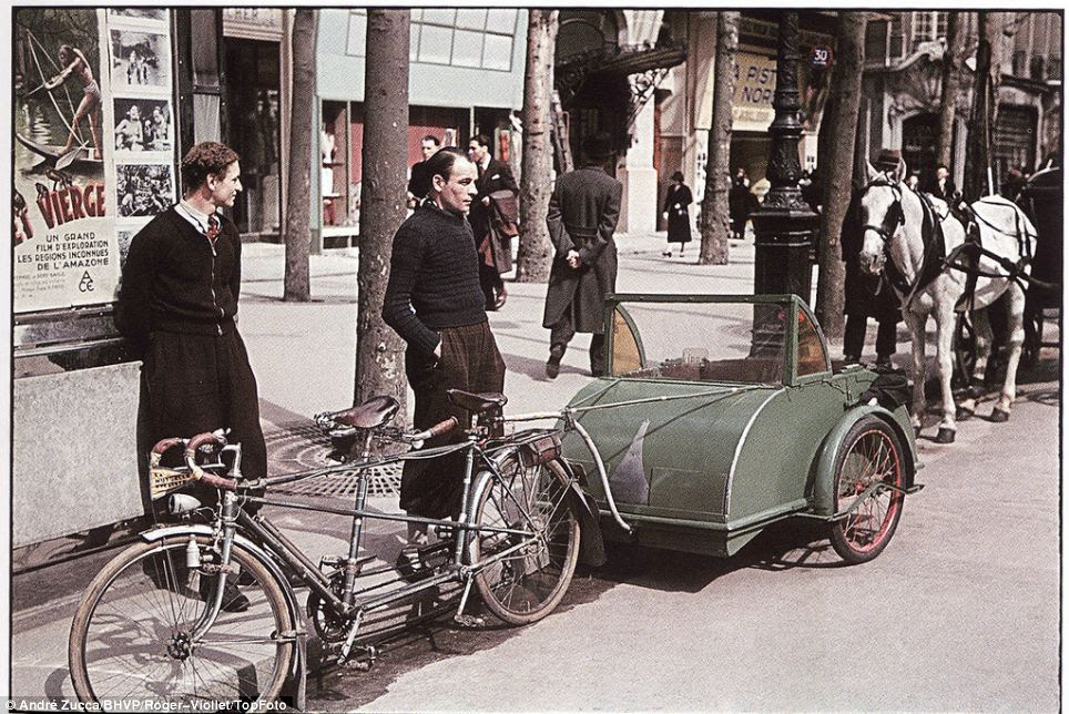 Ingenious contraption: Two fashionably dressed young men stand by a tandem bicycle towing a carriage of sorts