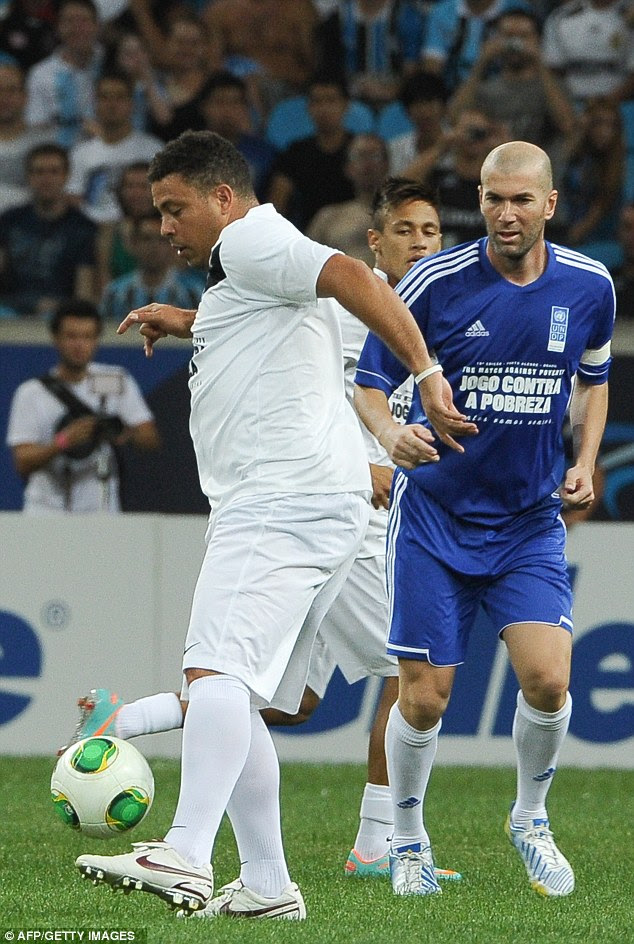 Meeting of legends: Ronaldo tries to steer the ball away from Zidane in their charity match