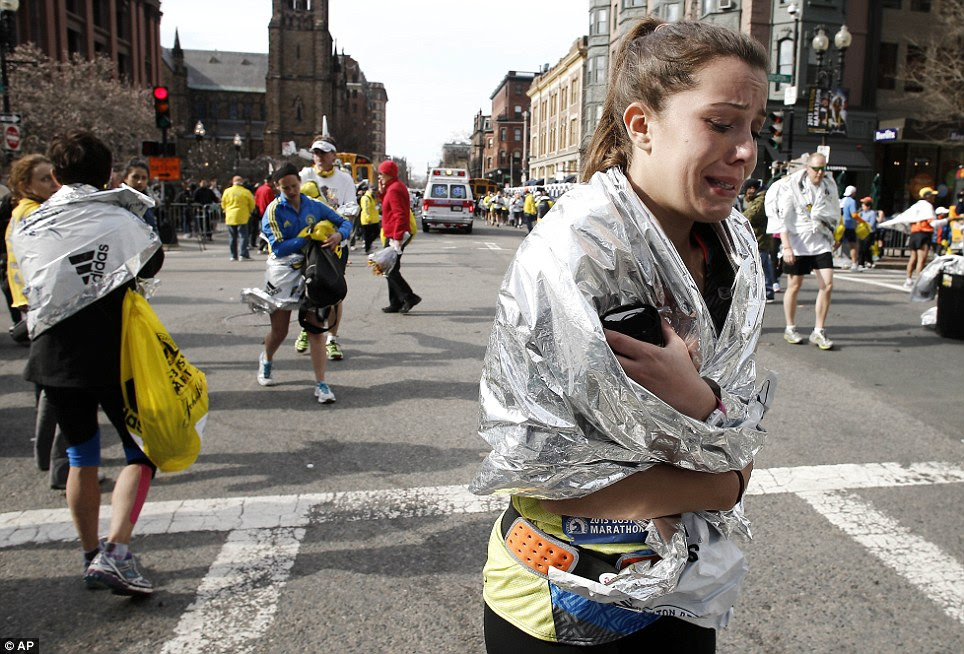 An unidentified Boston Marathon runner leaves the course crying near Copley Square