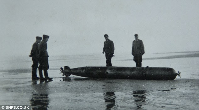 Germans examine a washed up torpedo in the set of some 200 astonishing pictures 