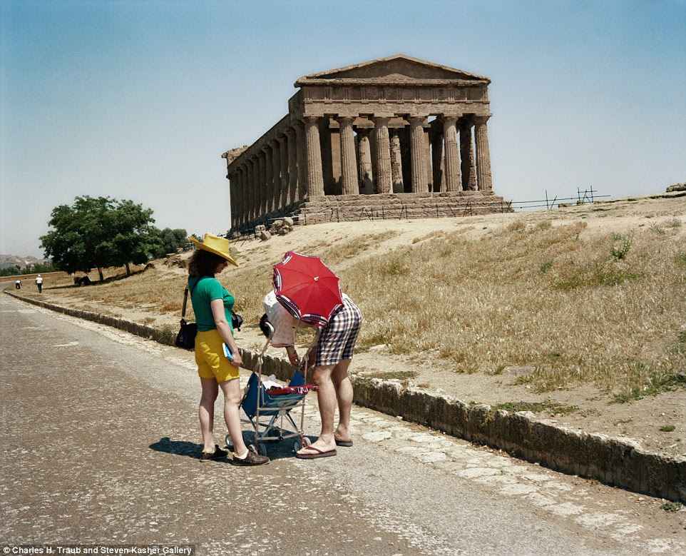 A couple adjusts their baby's pushchair and parasol in front of the Temple of Concordia in Agrigento, Sicily, in 1981