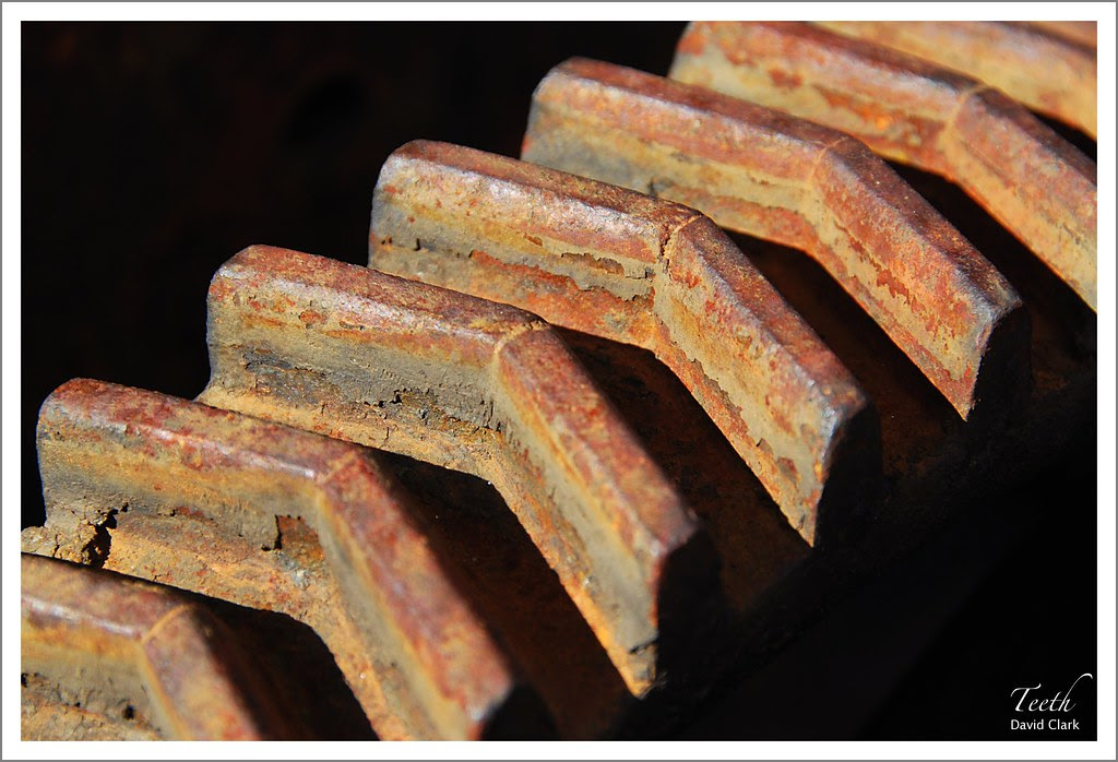 A macro image of the teeth on a rusted gear.
