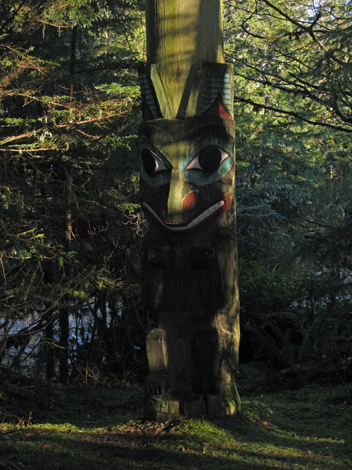a totem catches some afternoon light through the trees of Kasaan Totem Park, Kasaan, Alaska