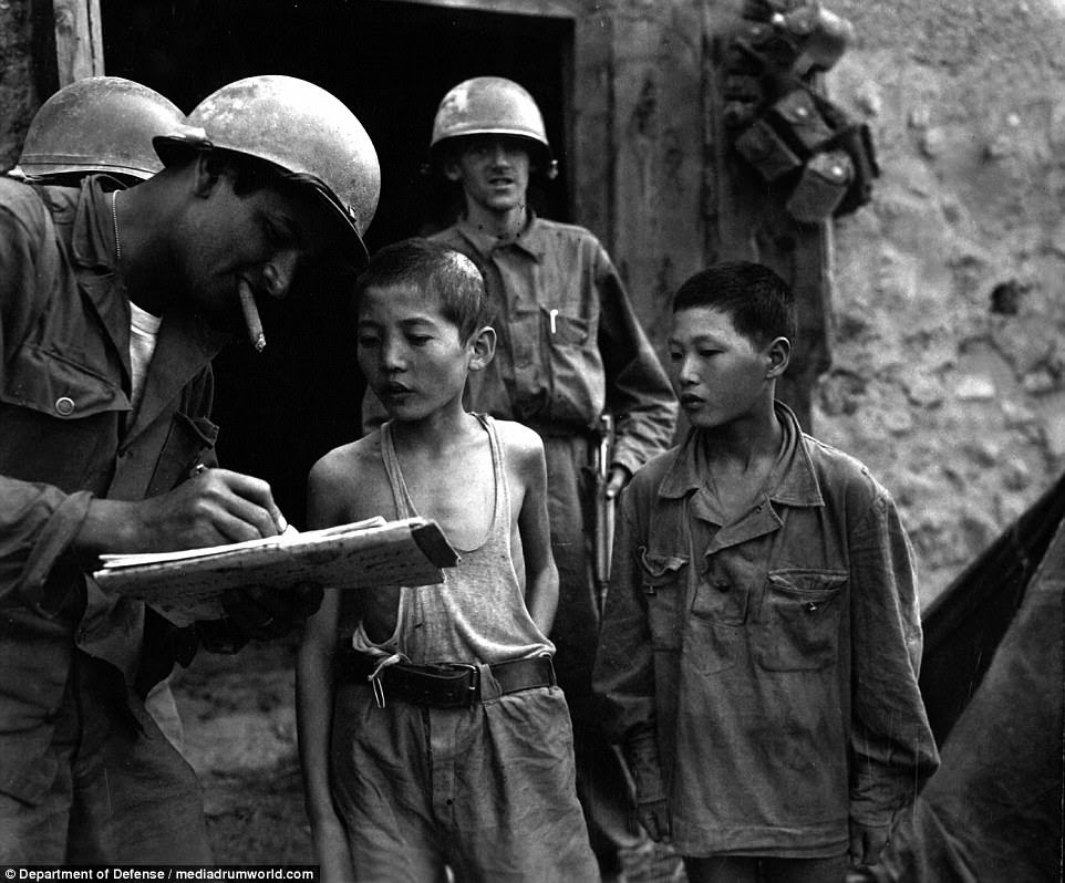 Two North Korean boys, serving in the North Korean Army, taken prisoner in the Sindang-dong area by elements of the 389th Inf. Regiment, are interrogated by a U.S. soldier shortly after their capture in September 1950