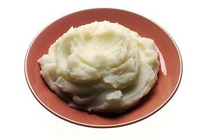 A small plate with a serving of mashed potatoes.