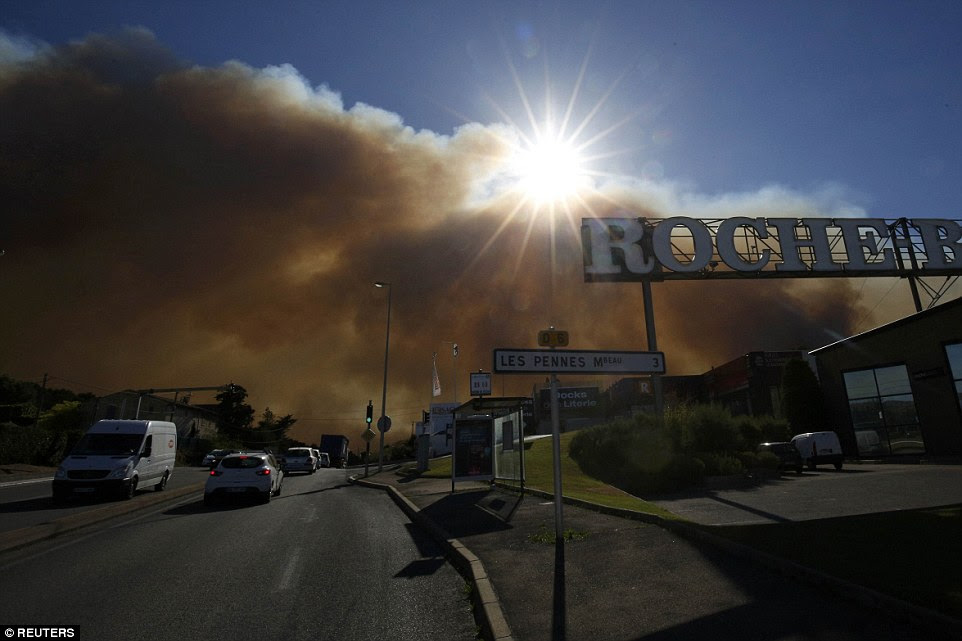 Smoke pendura baixo, uma vez que enche o céu enquanto os incêndios queimam norte de Marselha
