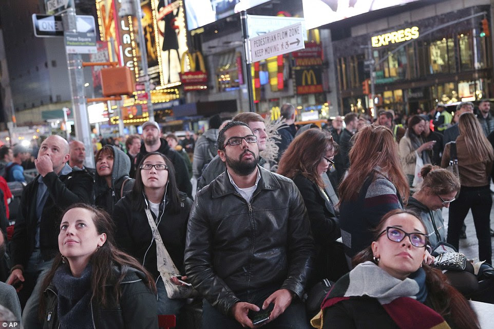 Pedestres assistir os resultados das eleições em telas grandes em Times Square, Nova York, na terça-feira