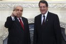 Cyprus's new President Anastasiades stands next to his predecessor Christofias at the presidential palace in the capital Nicosia