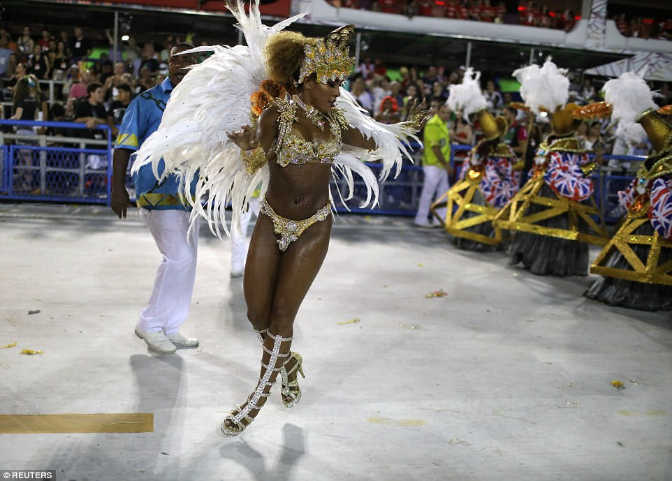 A dancer carrying a white display of feathers from Paraiso do Tuiuti Samba school performs in front of a crowd of 72,000 
