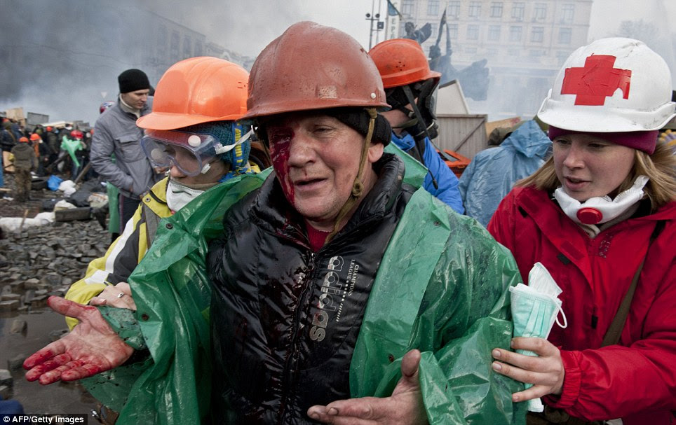Bloodied, yet undbowed: A wounded anti-government protester is evacuated during the violence