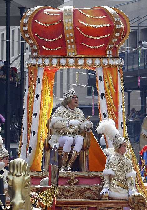 King of Carnival: Beads dangle from wires and revellers shout from balconies as masked members of The Rex Parade make their way through the citycity