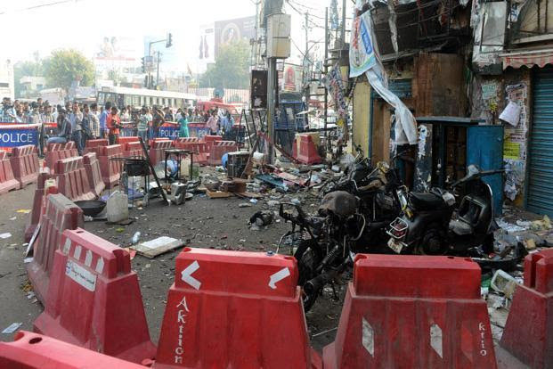 Police and pedestrians look on at the site of the bomb blast at Dilsukh Nagar in Hyderabad on Saturday. Photo: AFP
