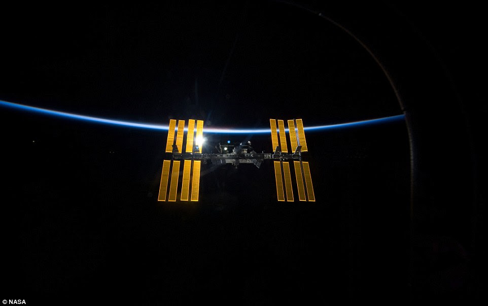 The ISS (pictured) orbits at a height of about 255 miles (410km). It has a total mass of about 990,000 pounds (450,000kg) and has living space roughly equivalent to a five-bedroom house The ISS (pictured) orbits at a height of about 255 miles (410km). It has a total mass of about 990,000 pounds (450,000kg) and has living space roughly equivalent to a five-bedroom house