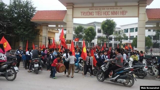 Học sinh nghỉ học đi biểu tình phản đối việc tịch thu bãi giữ xe để xây trung tâm thương mại ở xã Ninh Hiệp.