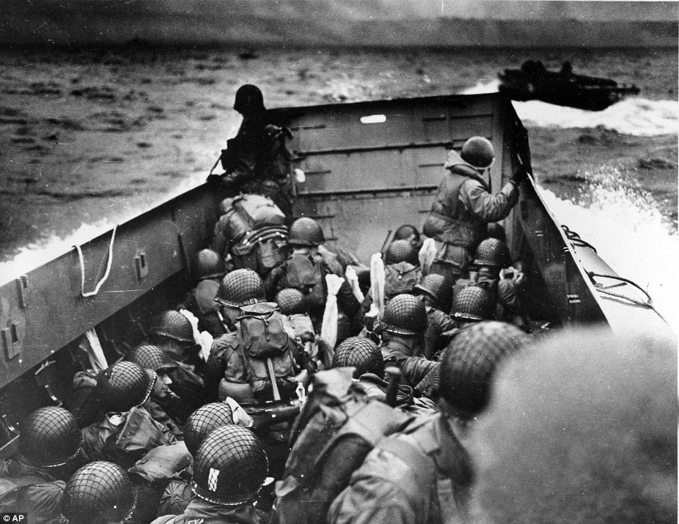 D-Day landings: A U.S. Coast Guard landing barge, tightly packed with helmeted soldiers, approaches the shore at Normandy, France, during initial Allied landing operations, on June 6, 1944