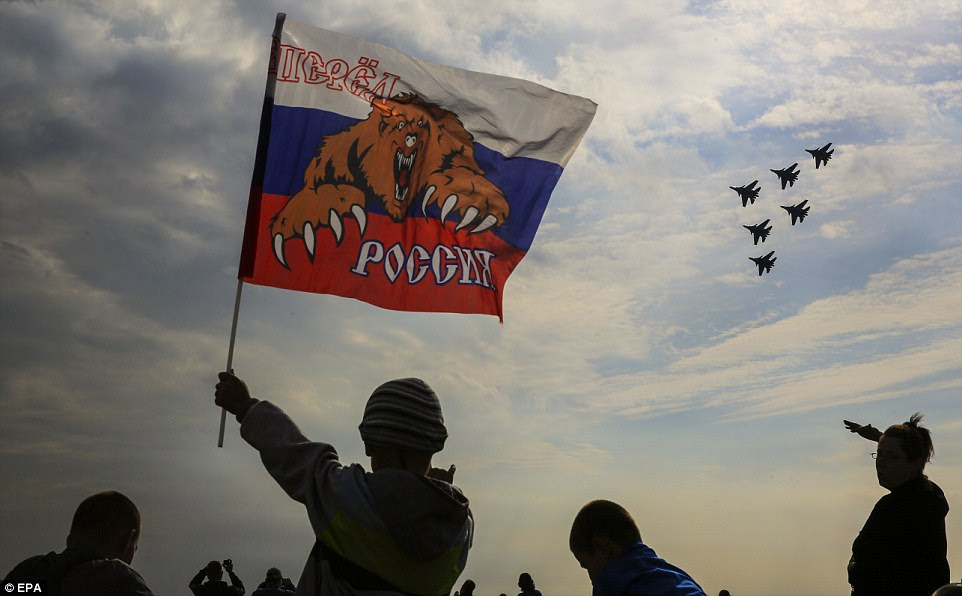 One boy was spotted waving a Russian flag with the slogan 'Russia forward' as the jets flew in formation through the skies