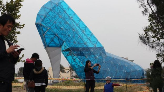 Tourists take pictures in front of a shoe-shaped church in southern Chiayi on 11 January, 2016