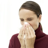 Photo of woman sneezing as part of having seasonal flu.