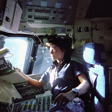 In this June 1983 photo provided by NASA, astronaut Sally Ride, a specialist on shuttle mission STS-7, monitors control panels from the pilot's chair on the shuttle Columbia flight deck.