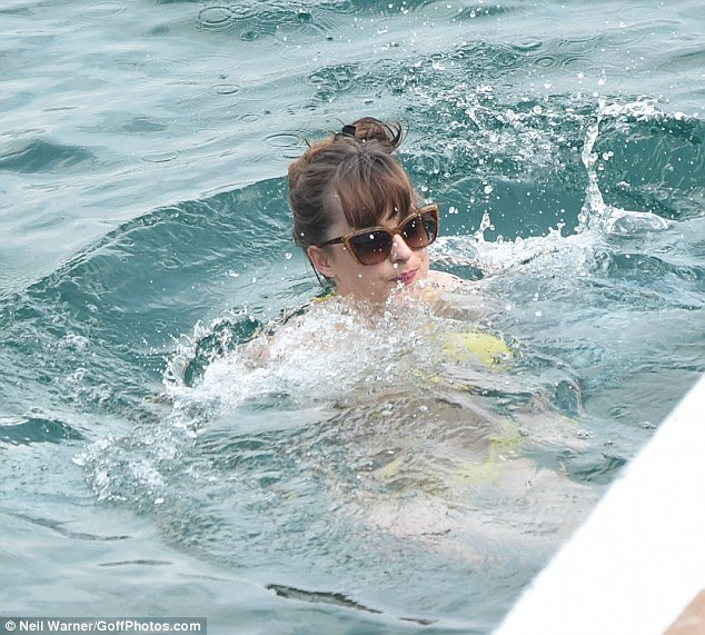 Mergulho dentro! Dakota lutou para manter acima da água enquanto ela brincando brinca no mar